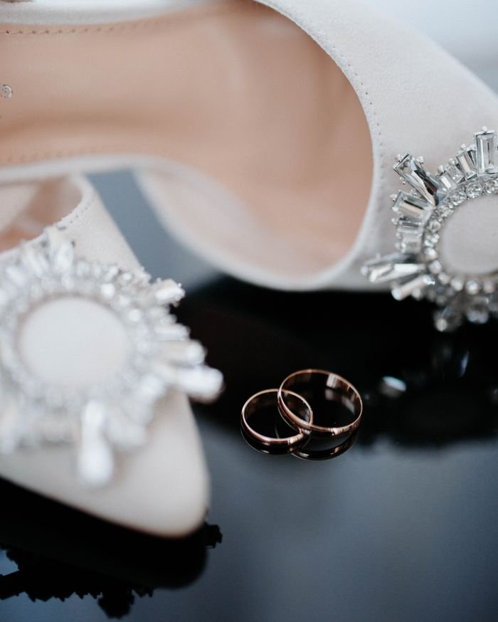 Close-up of luxury shoes with diamond embellishments and elegant rings on display